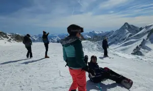 Sztruks na stoku. Grupa narciarzy i snowboardzistów podziwia alpejskie krajobrazy.