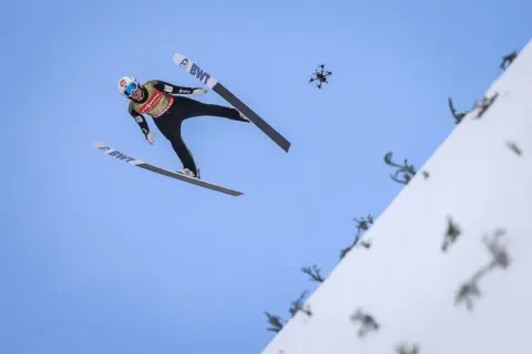 Skoczek narciarski w locie, a obok dron. Zastanawiasz się, ile ważą narty skoczków, by osiągnąć taką odległość?