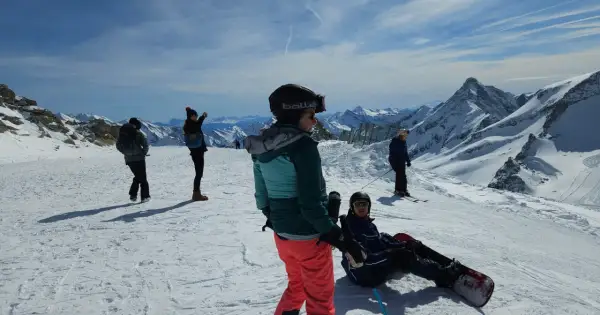 Sztruks na stoku. Grupa narciarzy i snowboardzistów podziwia alpejskie krajobrazy.